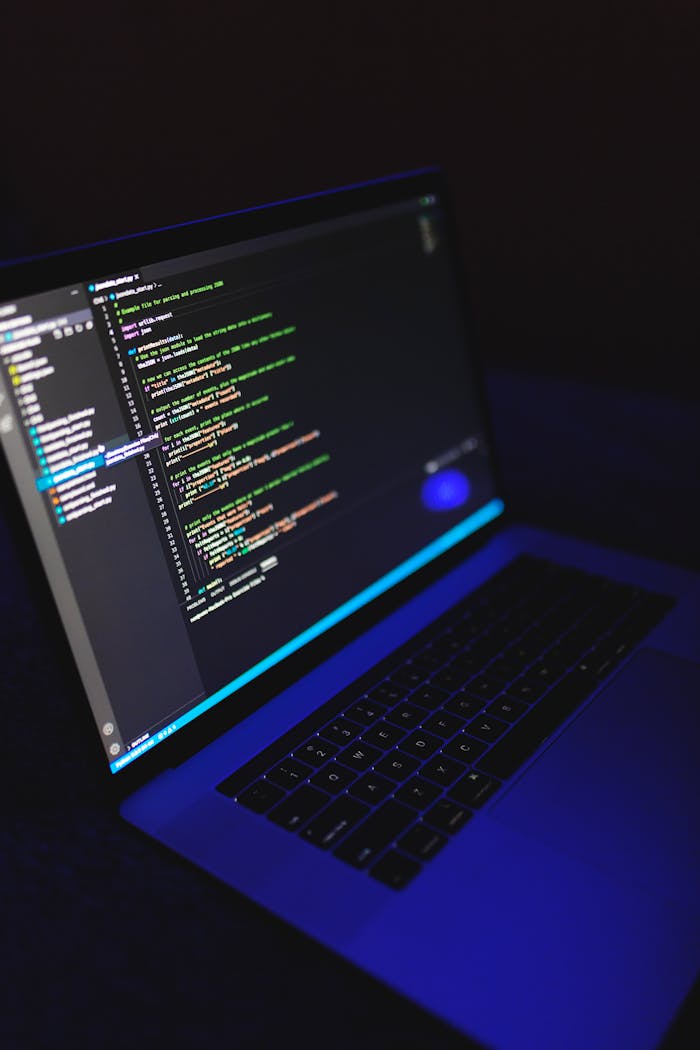A laptop showcasing colorful code in a dark environment, ideal for tech or programming content.